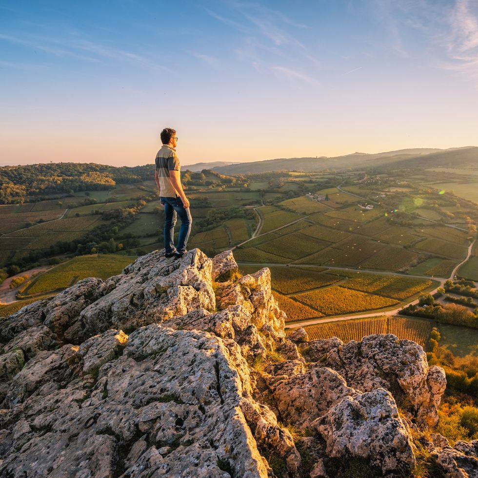 Man admiring the view from the top of Rock of Solutre at sunset, Burgundy, France