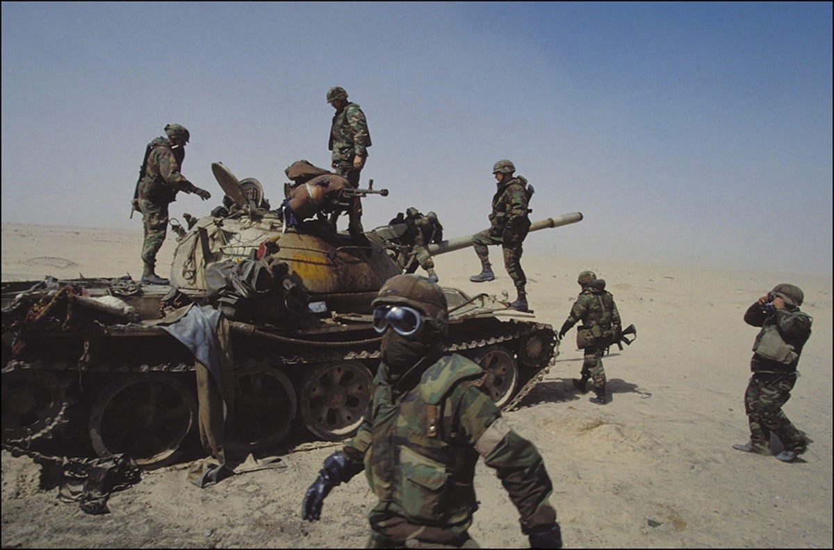 Amerikaanse soldaten onderzoeken een Iraakse tank die in februari 1991 is vernietigd nadat 35 landen de handen ineen hebben geslagen om Koeweit te bevrijden van de militaire bezetting door de Iraakse dictator Saddam Hoessein