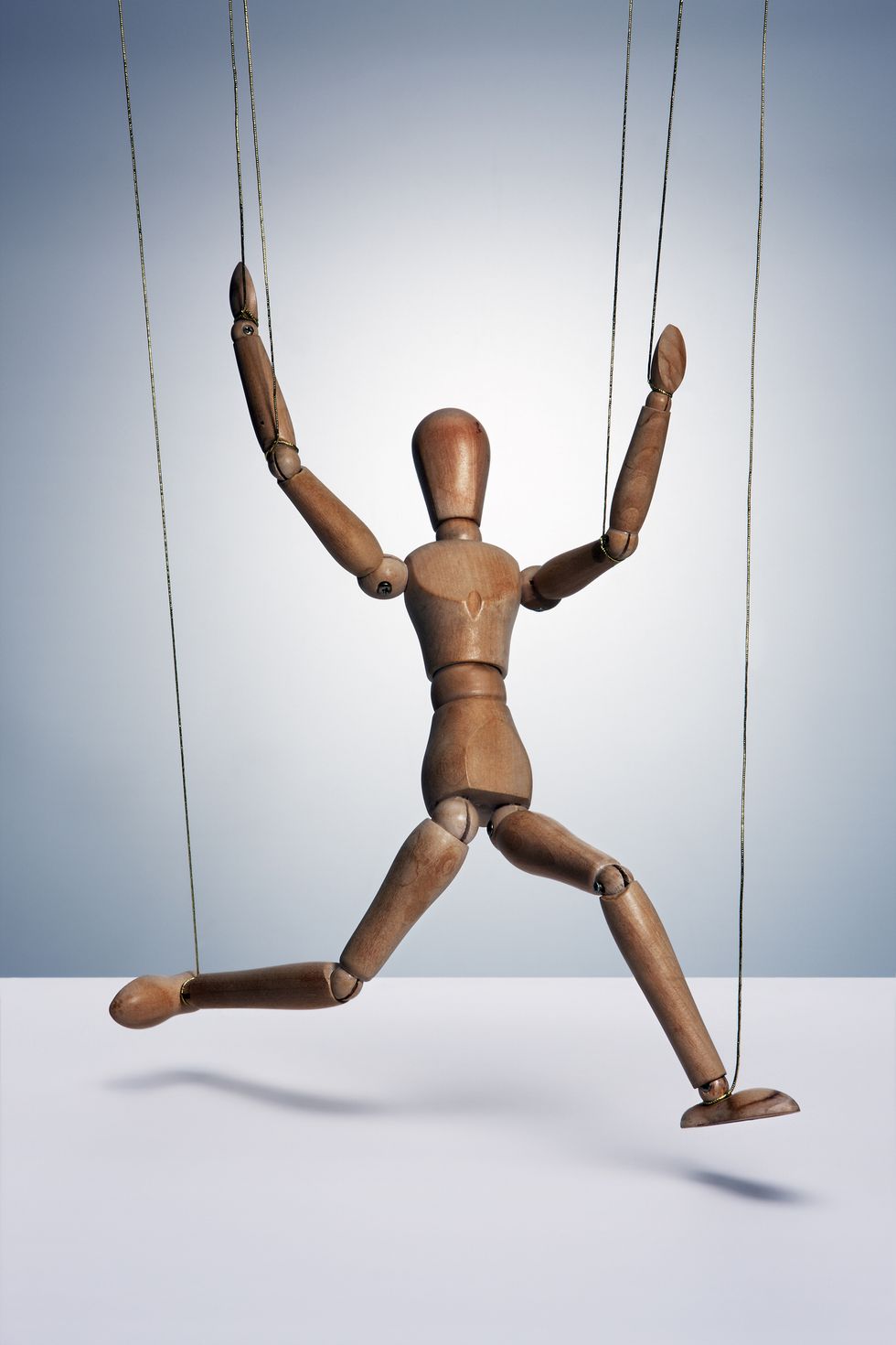 a wooden man controlled by strings