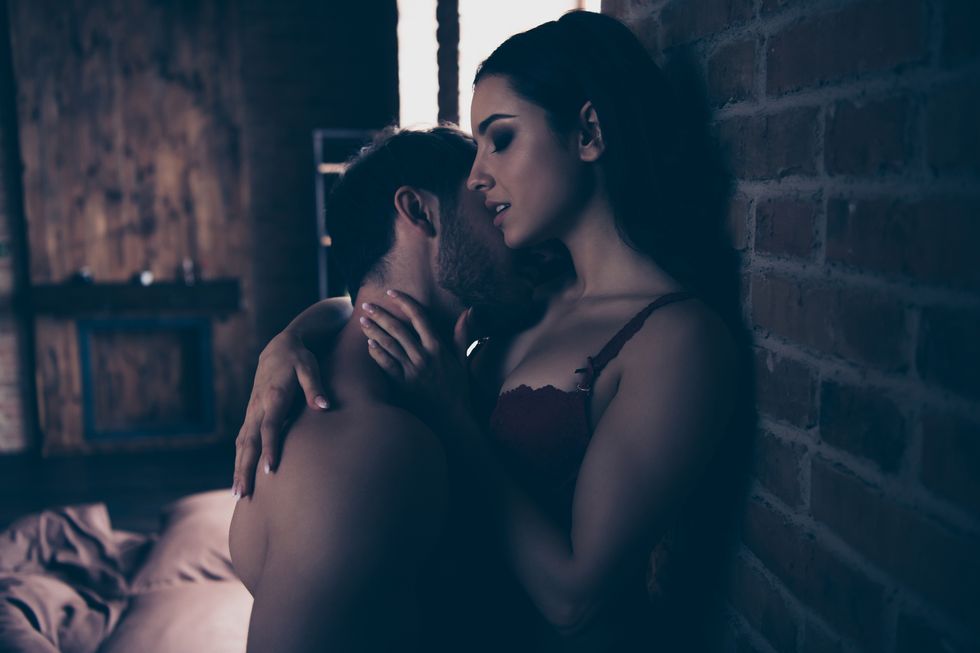 profile side view portrait of two gorgeous attractive fascinating people married spouses muscular body naughty horny tenderness touch hispanic caressing pleasure in dark loft industrial interior