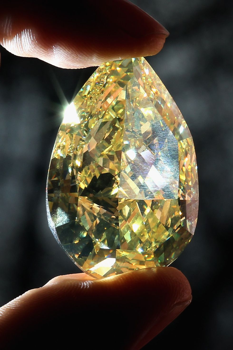 london, england   february 24  a rare yellow pear shaped diamond is held during a photocall at the natural history museum on february 24, 2011 in london, england the 11003 carat diamond, which is on loan from leading specialised diamond manufacturers cora international, is the largest yellow pear shaped diamond in the world and goes on display in the vault at the natural history museum in london from february 25, 2011  photo by dan kitwoodgetty images