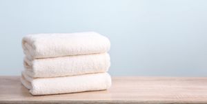 stack of white terry towels on wooden table empty space background