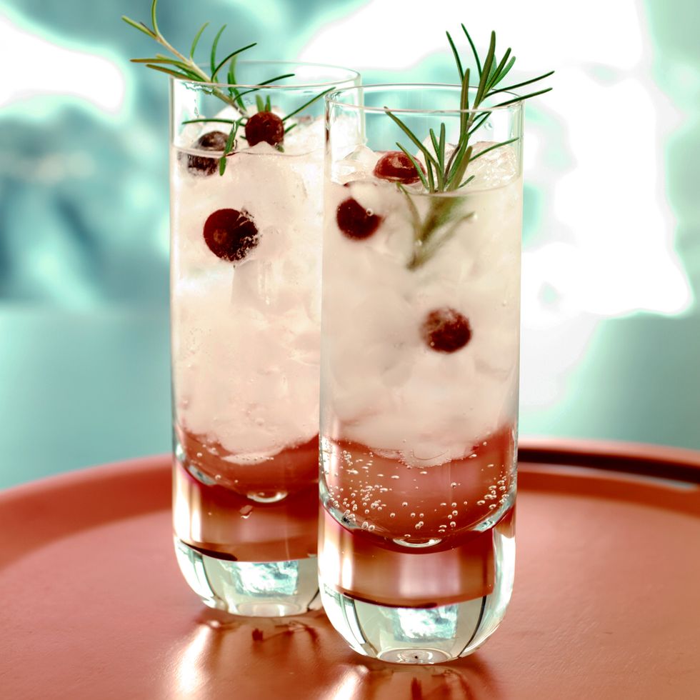 cocktail garnished with rosemary and cranberries