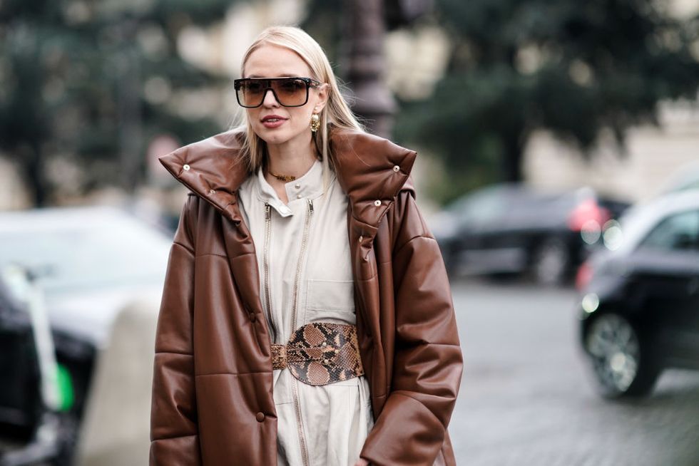paris, france   january 22 leonie hanne wears a brown long puffer coat, a vuitton bag, a white jumpsuit, a snake print large belt, snake print boots, outside alexandre vauthier, during paris fashion week   haute couture spring summer 2020, on january 22, 2019 in paris, france photo by edward berthelotgetty images