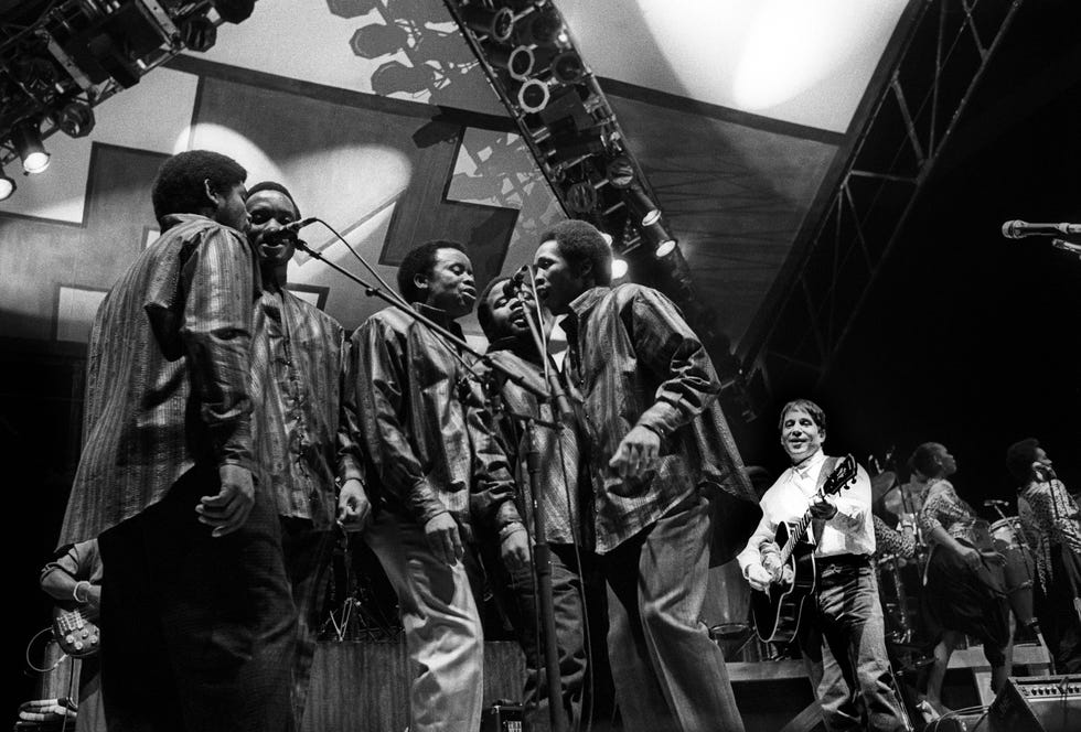 Paul Simon performs live on stage with fellow musicians from the Graceland tour at Ahoy in Rotterdam, the Netherlands on February 1, 1987