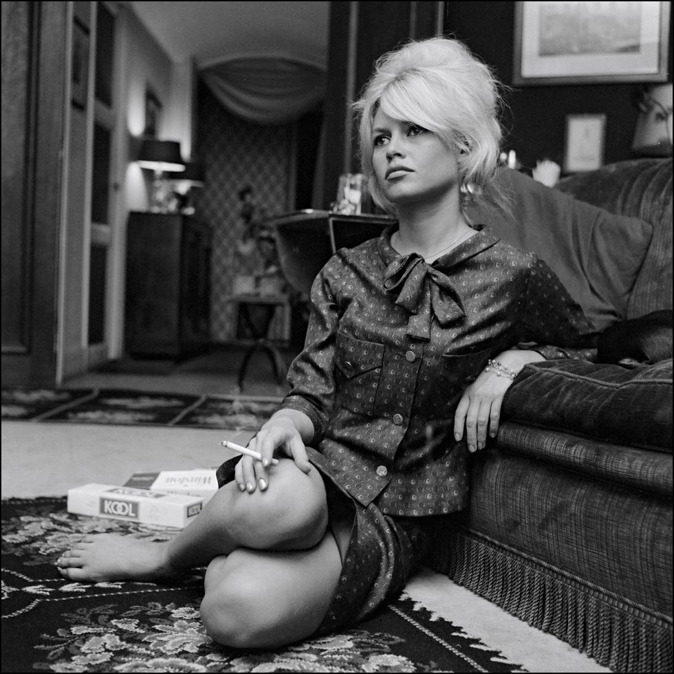Brigitte Bardot sentada en su casa en 1962 con camisa de lazo