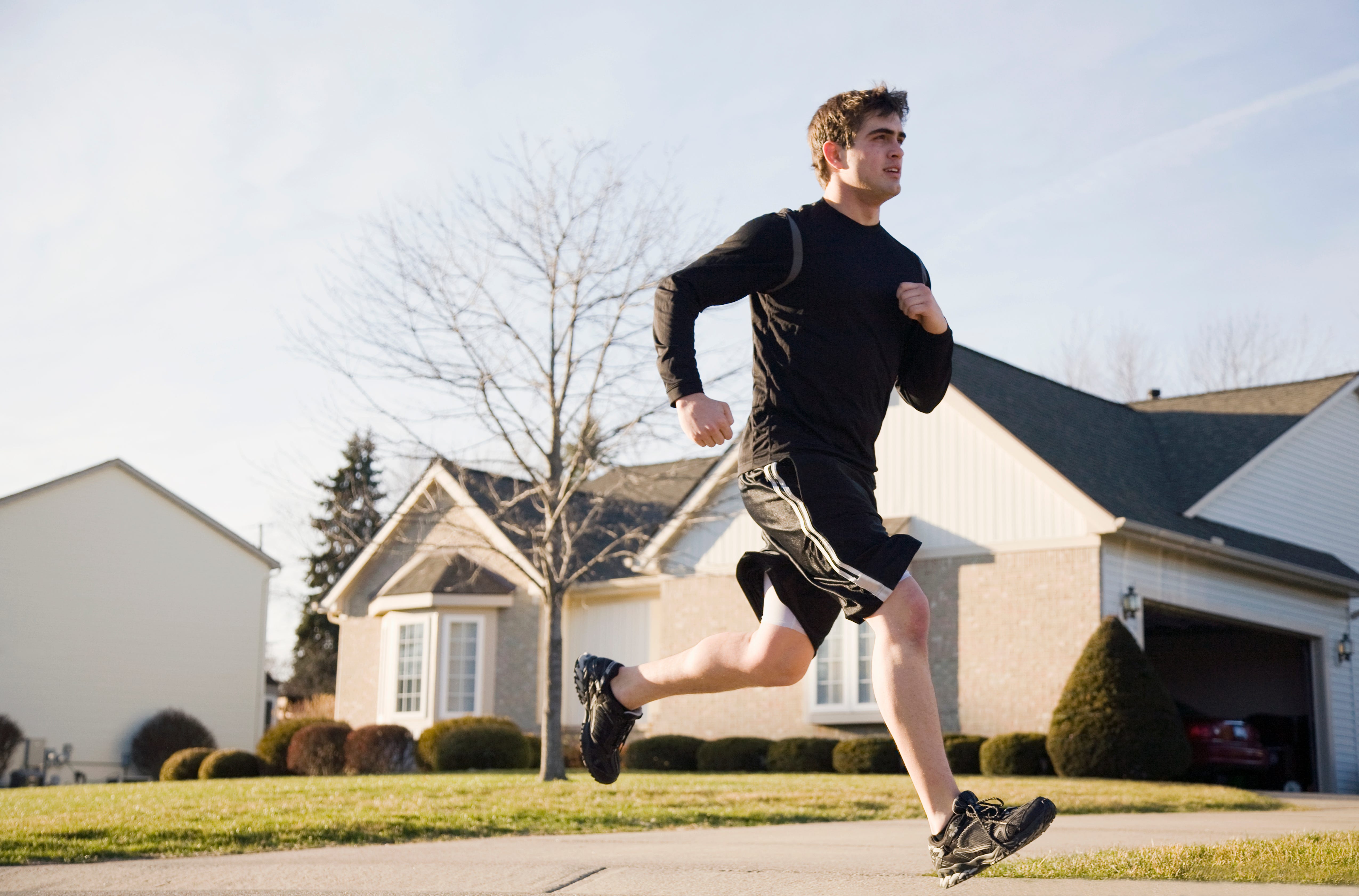 Young man running on suburban road