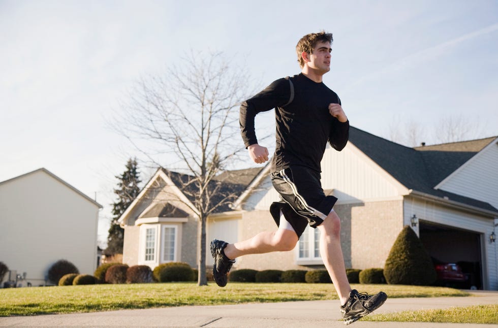 Young man running on suburban road