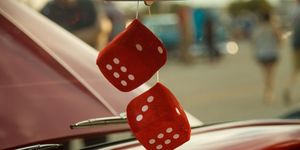 fuzzy retro red dice hanging from a mirror in a red car
