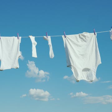 White linen dries on a rope against a clean blue sky snow white white linen dries on a rope against a blue sky background.