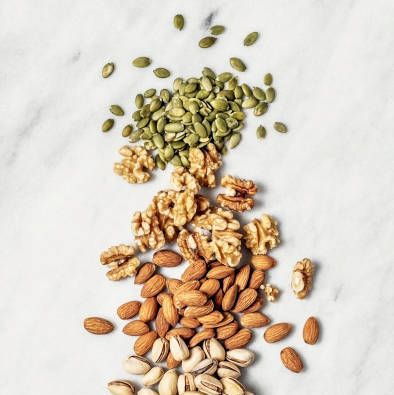 nuts pistachios, walnuts, and almonds and seeds pumpkin and sunflower on white background