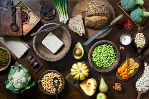 overhead shot of healthy vegan food including fruit vegetables tofu and beans