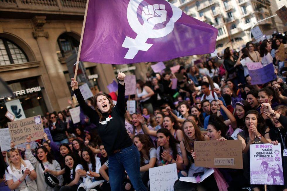 a woman waves a feminist flag as student protesters shout slogans during a demonstration marking international womens day in barcelona on march 8, 2019 unions, feminist associations and left wing parties have called for a work stoppage for two hours on march 8, hoping to recreate the strike and mass protests seen nationwide to mark the same day in 2018 photo by pau barrena afp photo by pau barrenaafp via getty images