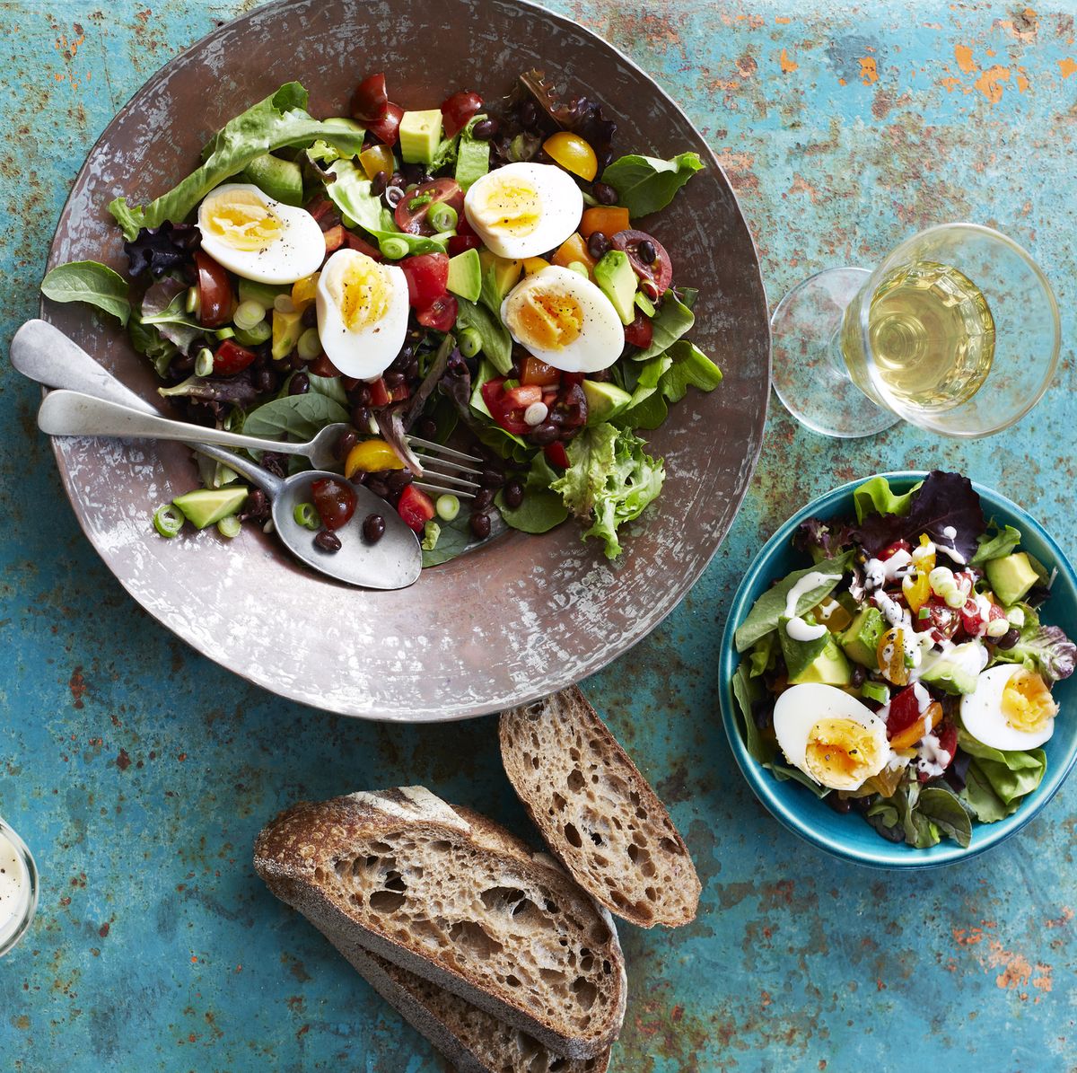 Still life of salad with boiled eggs, beans and brown bread
