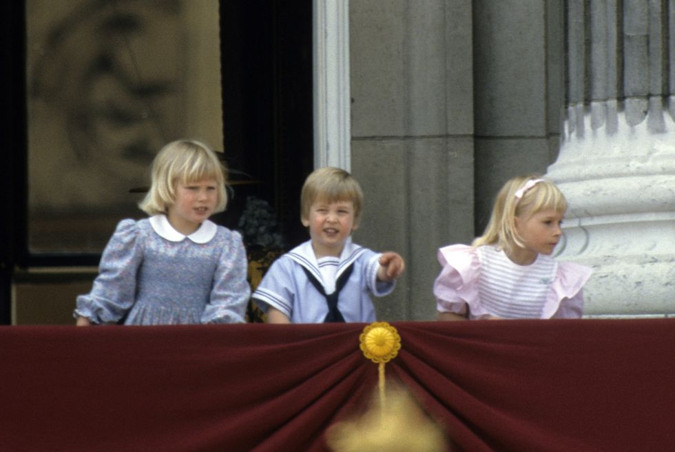 london, england   june 15  prince william points from the balcony of buckingham place with his cousin zara phillips l and lady davina windsor r following trooping the colour on june 15, 1985 in london, england photo by anwar husseingetty images