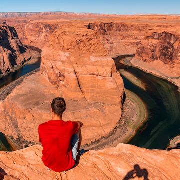 young man exploring horseshoe bend by the river colorado near the town of page arizona, usa beautiful hiking trails in the grand canyon