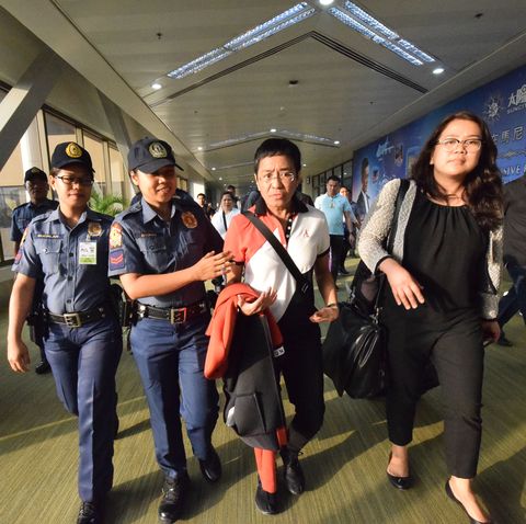 philippine journalist maria ressa is escorted by police after an arrest warrant was served, shortly after arriving at the international airport in manila on march 29, 2019