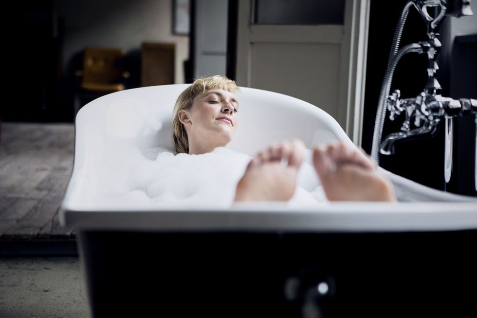 blond woman taking bubble bath in a loft