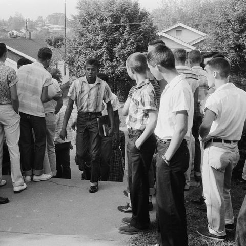 School integration conflicts, Little Rock, Arkansas. Photograph shows an African American boy walking through a crowd of white boys during a period of violence related to school integration. 1957. Thomas J O'Halloran, photographer.
