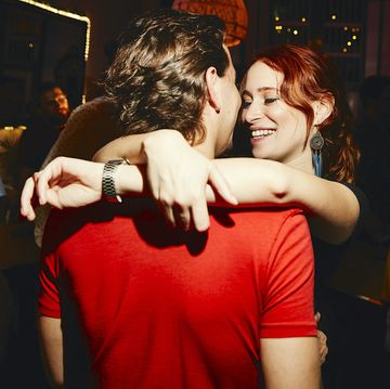smiling woman embracing boyfriend during party in night club