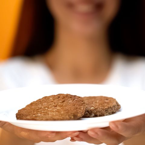 Woman holding cutlets, percentage of soya meat in burgers, fast food quality