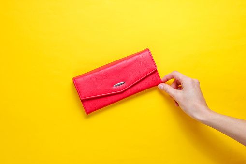 minimalism trend female hand takes red leather wallet
