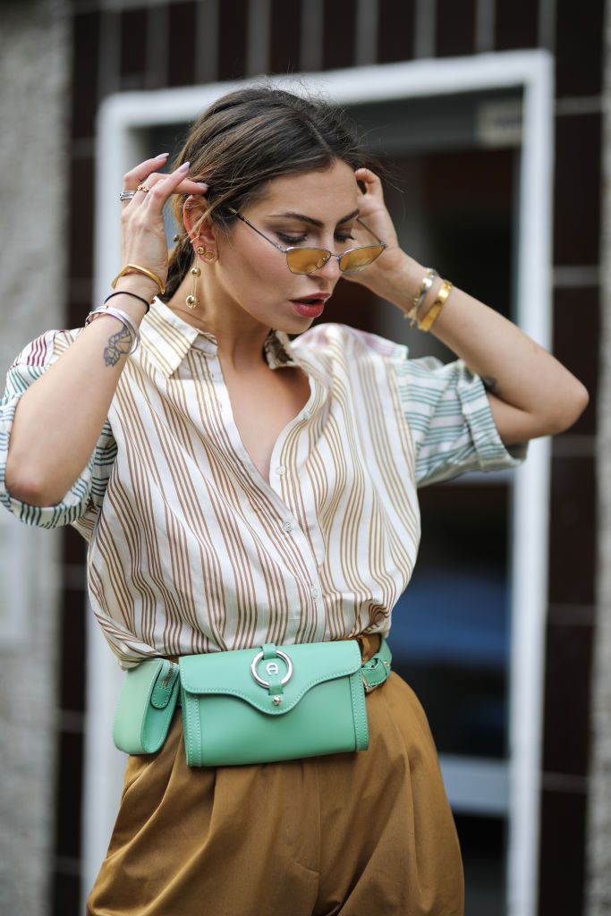 berlin, germany   march 19 masha sedgwick maria astor wearing bally wide pants, sandro stripes shirt, bash mustard yellow coat, green aigner belt bag, marc jacobs sunnies, tiffany  co earring on march 19, 2019 in berlin, germany photo by jeremy moellergetty images