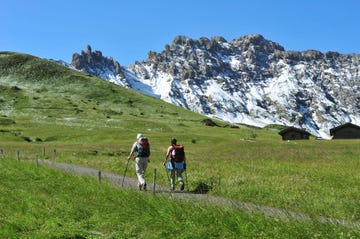 hikers on a path in the seiser alm, schlern rosengarten nature park, dolomites, trentino alto adige, italy