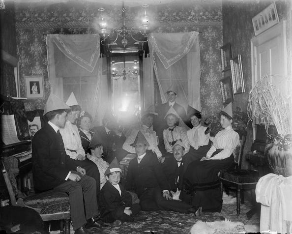 vintage birthday photos men, women and children seated in chairs and on the floor wearing paper hats in honor of aunt helens birthday, sturgeon bay, wisconsin, may 20, 1902. a piano is on the right, a chandelier hangs from the ceiling, and a mirror and framed pictures are on the walls. (photo by harry e. dankoler/wisconsin historical society/getty images)
