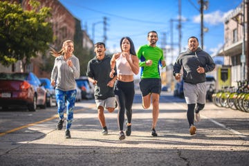 full length of men and women jogging on street young runners are exercising in city they are in sportswear during training