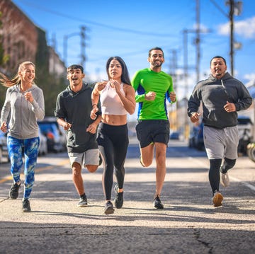 Runners jogging on the street in the city full length of men and women jogging on street young runners are exercising in city they are in sportswear during training
