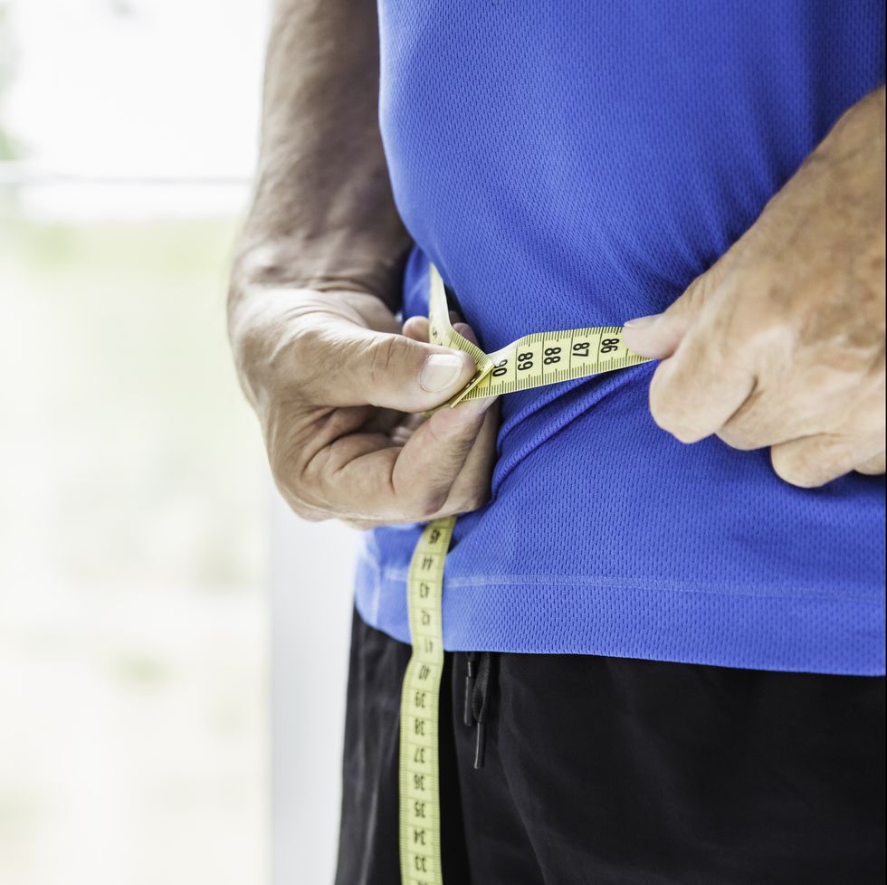 cropped shot of senior man measuring his waist cico diet