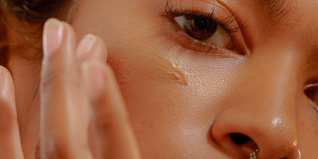 Closeup of a Young Confident Woman Applying Foundation