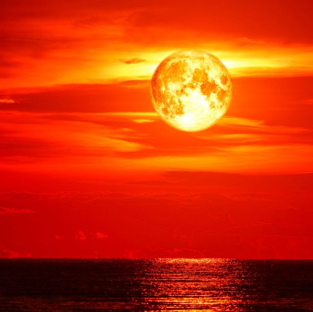 full blood moon on sea and ocean last light red sky silhouette cloud