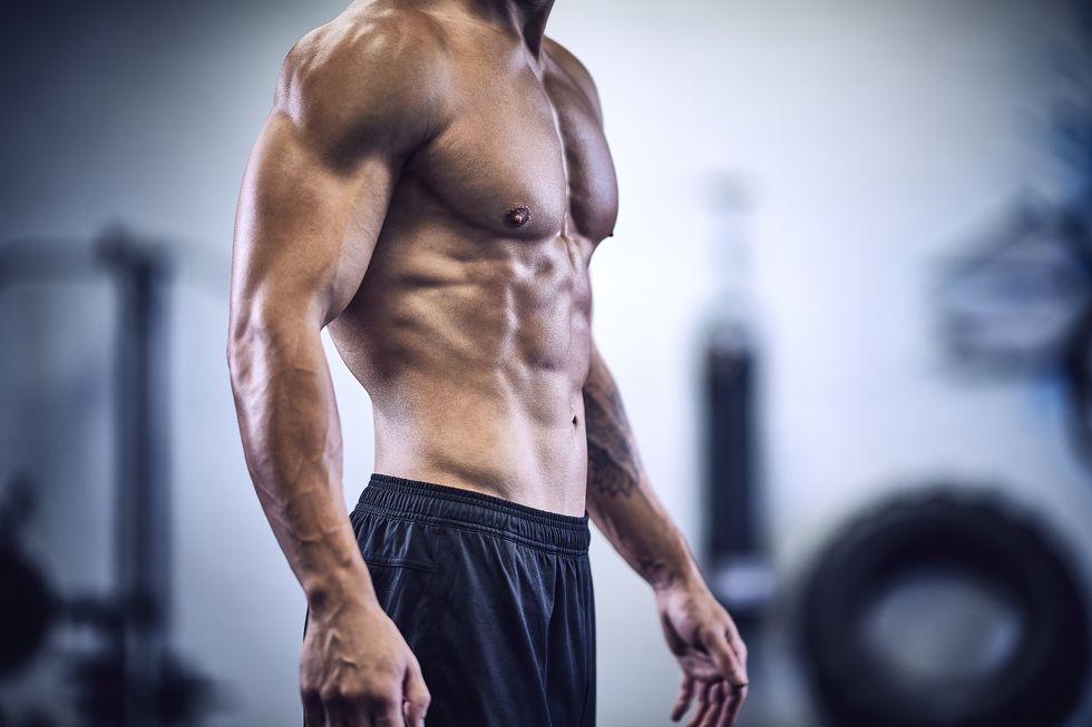 torso of muscular male bodybuilder in industrial gym
