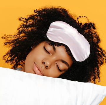 Sleeping. Dreams. Woman portrait. Afro American girl in pajama is hugging a pillow, on a yellow background sleeping. dreams. woman portrait. afro american girl in pajama is hugging a pillow, on a yellow background