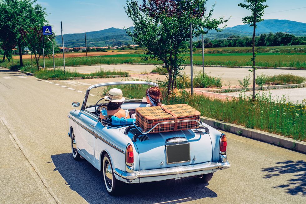 mature women on a road trip with old fashioned convertible