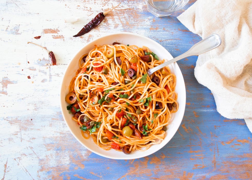 Traditional Itallian pasta spaghetti alla puttanesca with anchovies, tomatoes, olives, capers, garlic and parsley. T