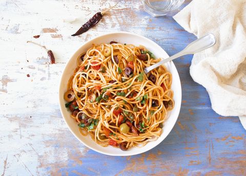 Traditional Itallian pasta spaghetti alla puttanesca with anchovies, tomatoes, olives, capers, garlic and parsley. T