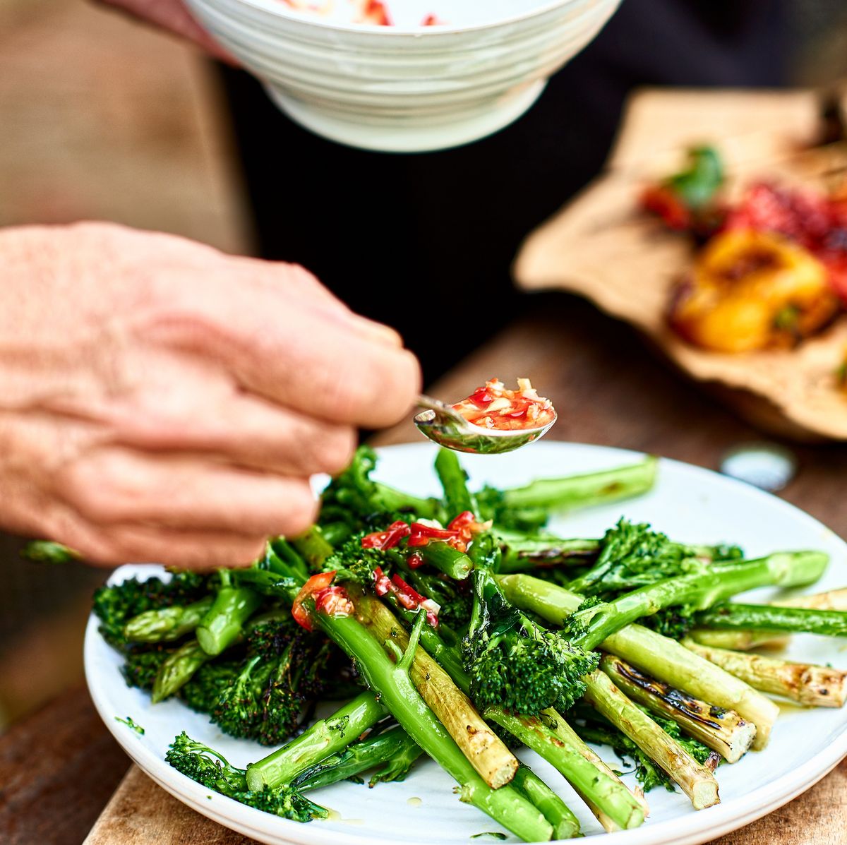dish with fresh green tenderstem brococli and asparagus and red chilli dressing, serving, plating up, food preparation, healthy eating