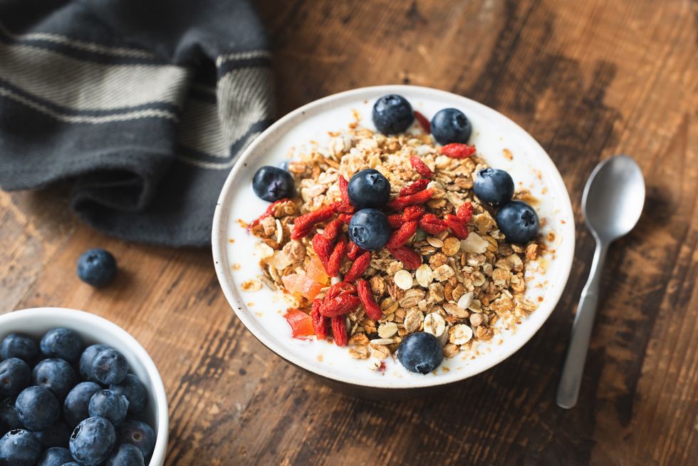 breakfasts for weight loss granola bowl with yogurt, blueberries and goji berries on old wooden table healthy vegetarian eating, healthy lifestyle concept