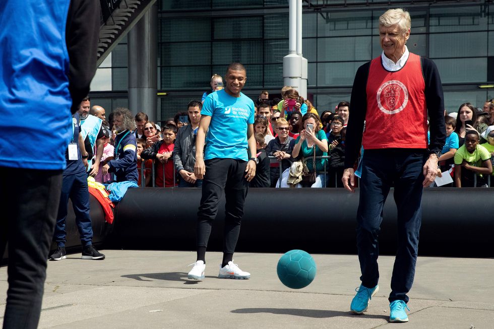 topshot   paris saint germains french forward kylian mbappe c and former arsenal football team manager arsene wenger r take part in a football match with children from the premiers de cordee association at the stade de france in saint denis, north of paris, on may 22, 2019 photo by joel saget  afp        photo credit should read joel sagetafp via getty images