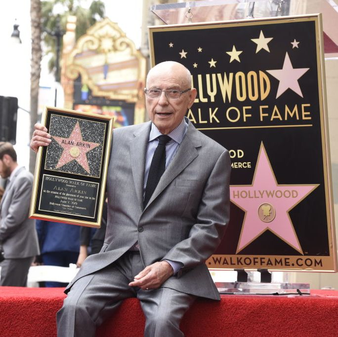 actor and filmmaker alan arkin sits holding his star on the hollywood walk of fame