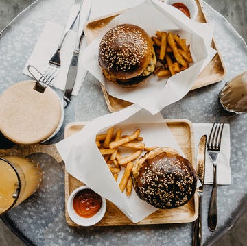 top view of burgers with french fries and drinks freshly served on table in cafe