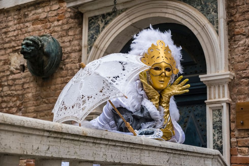 venice, veneto, italy   20190304 a feminine masked person in a beautiful creative costume, posing on a bridge in front of a house facade, celebrating the venetian carnival photo by frank bienewaldlightrocket via getty images