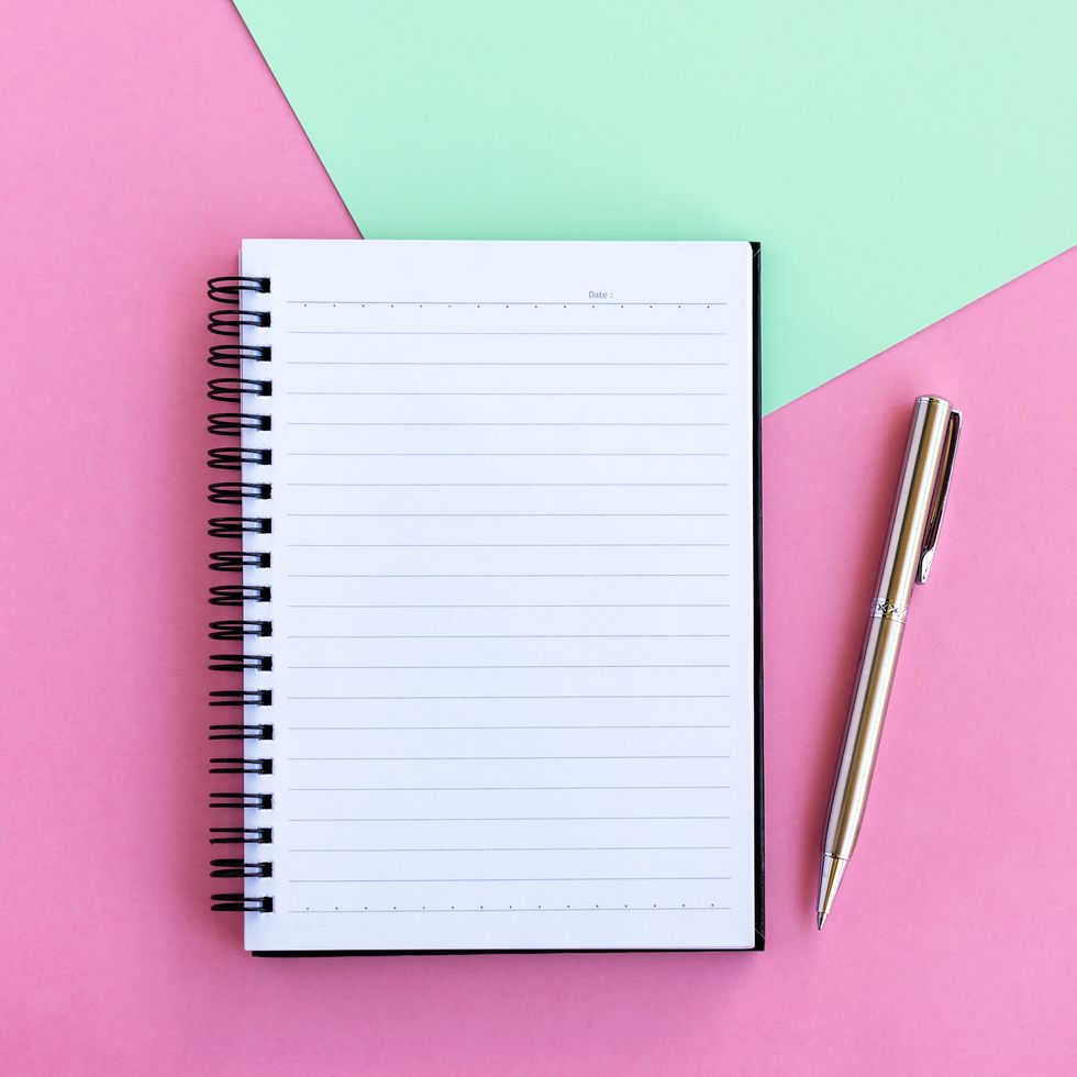Note Pad and Pen on Pink and Green Background