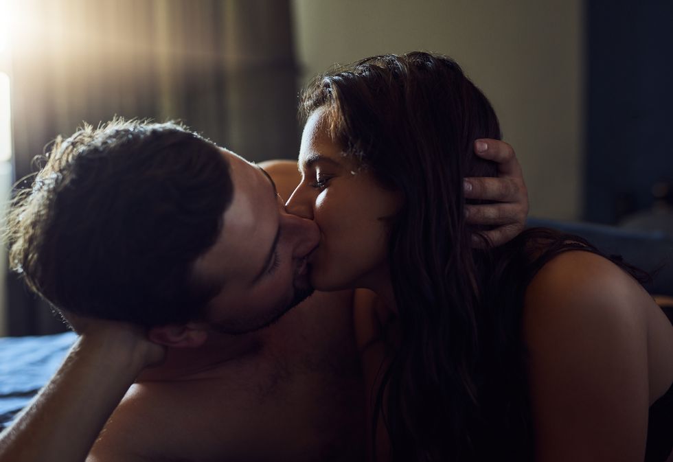 shot of an affectionate young couple sharing a kiss in their bedroom at home