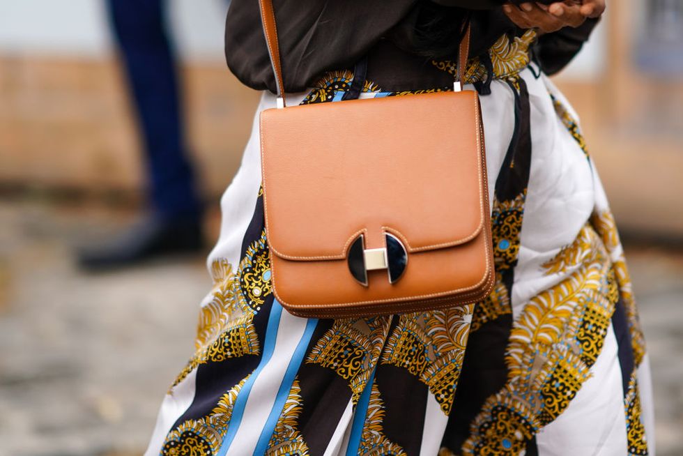 paris, france   june 22 a guest wears a scarf print skirt, a gold leather bag, outside hermes, during paris fashion week   menswear springsummer 2020, on june 22, 2019 in paris, france photo by edward berthelotgetty images