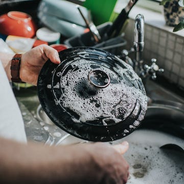 man washing dishes at a sink