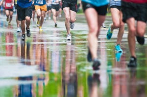 colorful outfits of marathon runners are reflected on rain soaked asphalt during ottawa international marathon